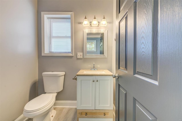 bathroom with toilet, hardwood / wood-style flooring, and vanity