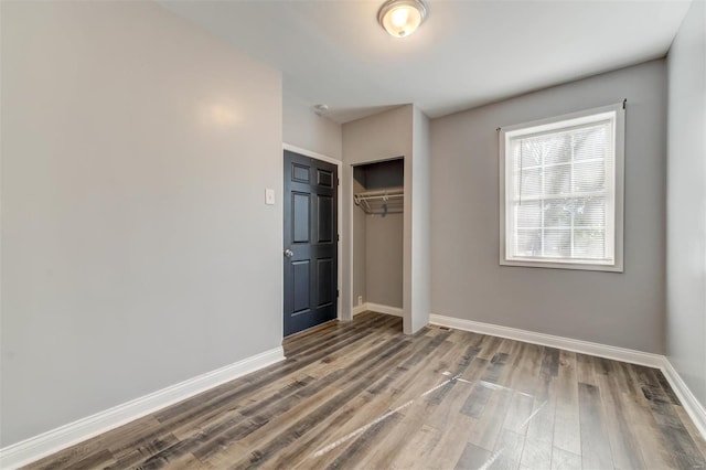 unfurnished bedroom with hardwood / wood-style floors and a closet