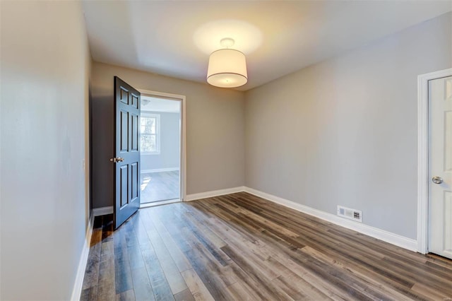 unfurnished room with dark hardwood / wood-style flooring