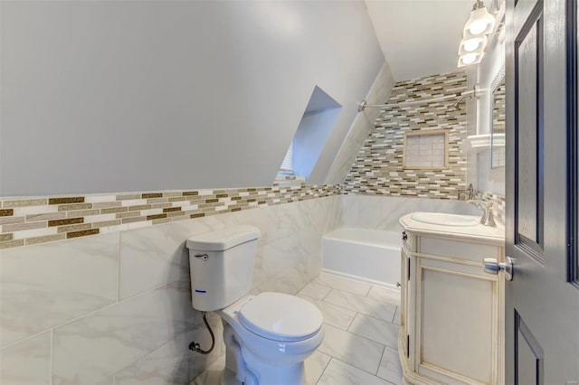 bathroom with tile walls, toilet, vanity, a tub to relax in, and tile patterned floors