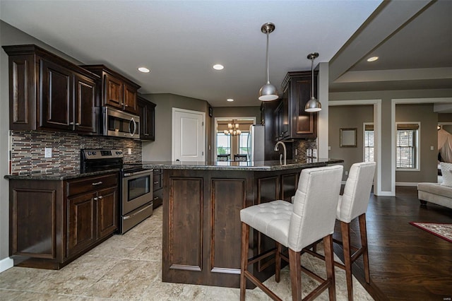 kitchen featuring backsplash, stainless steel appliances, plenty of natural light, and light wood-type flooring