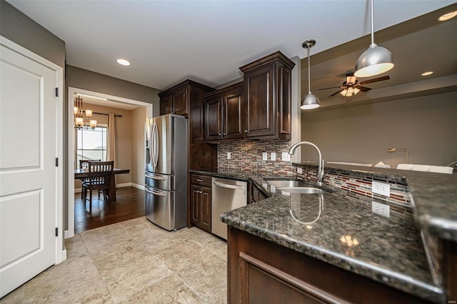 kitchen featuring backsplash, sink, decorative light fixtures, light wood-type flooring, and appliances with stainless steel finishes