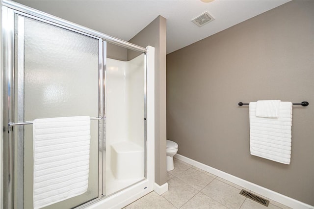 bathroom with tile patterned flooring, a shower with shower door, and toilet