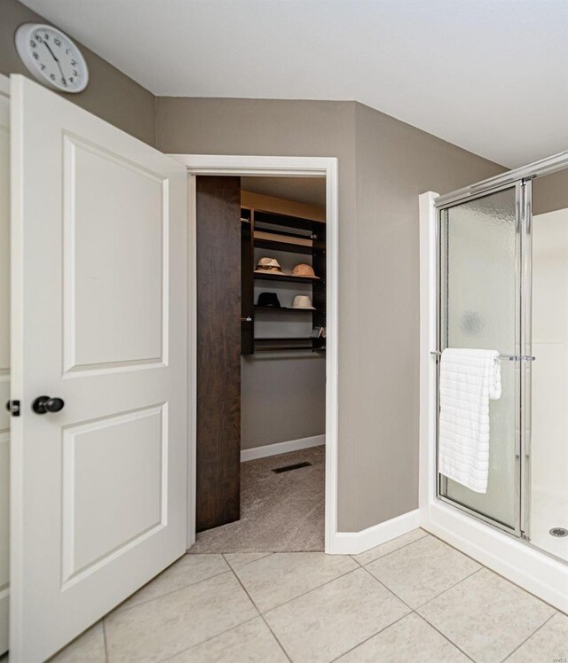 interior space with tile patterned flooring and a shower with shower door