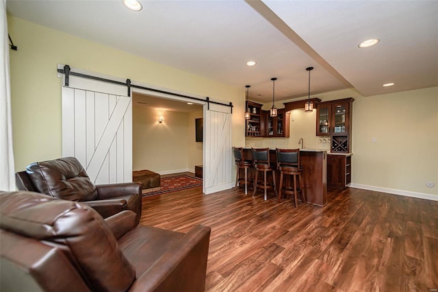 living room with sink, dark wood-type flooring, and a barn door