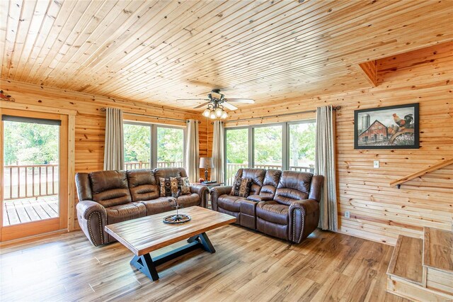 living room featuring ceiling fan, wooden walls, light hardwood / wood-style flooring, and wood ceiling