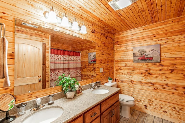 full bath with double vanity, wood finished floors, a sink, and wood ceiling