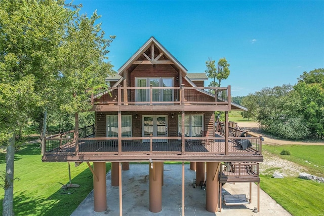 back of property with french doors, a lawn, a patio area, and a wooden deck