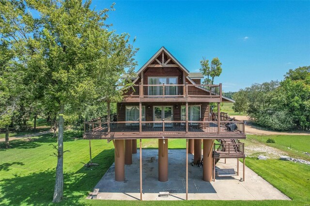 back of house with a wooden deck, a patio, and a yard