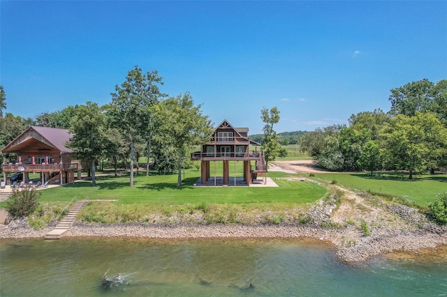 rear view of house with a lawn and a water view