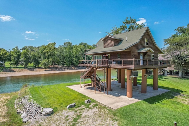 view of playground featuring a patio area, a lawn, a water view, and stairs