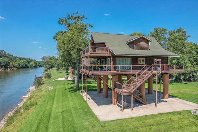 view of play area with stairs, a patio, a lawn, and a deck with water view