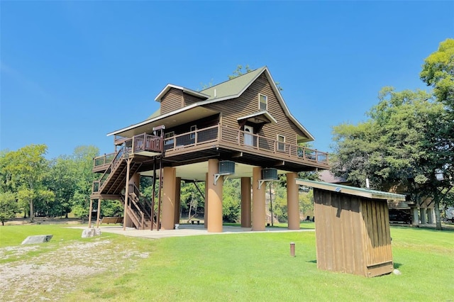 rear view of house with stairs, a deck, and a lawn