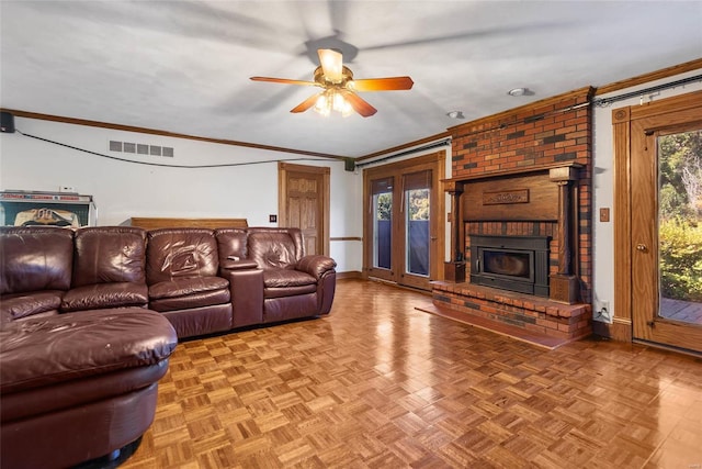 living room featuring crown molding, parquet flooring, a brick fireplace, and ceiling fan