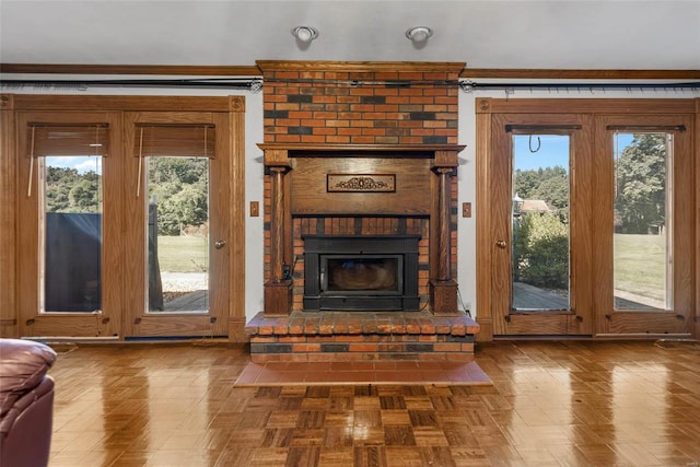 unfurnished living room with a fireplace, plenty of natural light, and parquet flooring