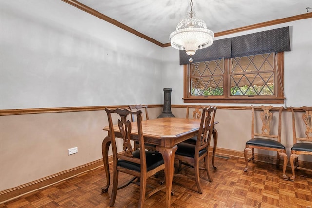 dining space with ornamental molding, a notable chandelier, and parquet flooring