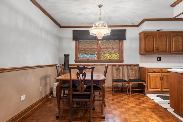 dining area featuring crown molding, parquet flooring, and a notable chandelier