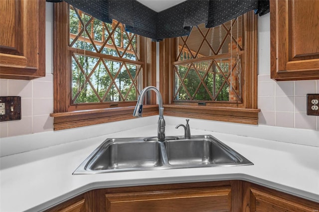 kitchen with a wealth of natural light, decorative backsplash, and sink