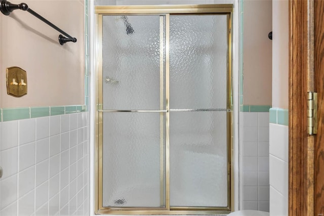 bathroom with tile walls and walk in shower