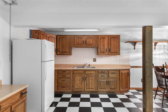 kitchen featuring white fridge, sink, and decorative backsplash