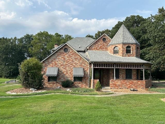 view of front of home with covered porch and a front lawn