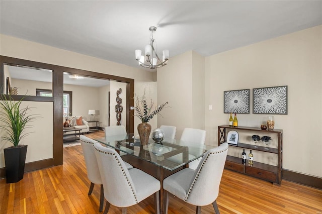 dining room featuring hardwood / wood-style flooring and an inviting chandelier