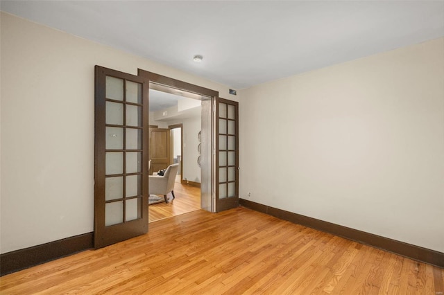 unfurnished room featuring light hardwood / wood-style floors and french doors