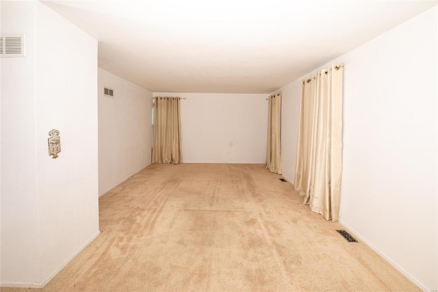 spare room featuring light colored carpet