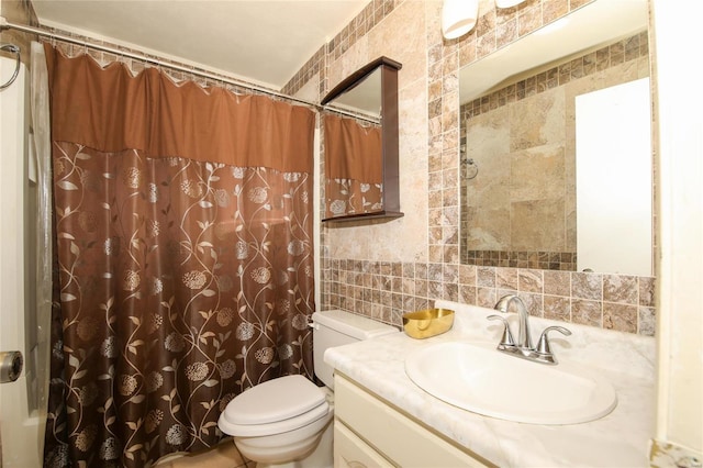 bathroom featuring vanity, toilet, and tile walls