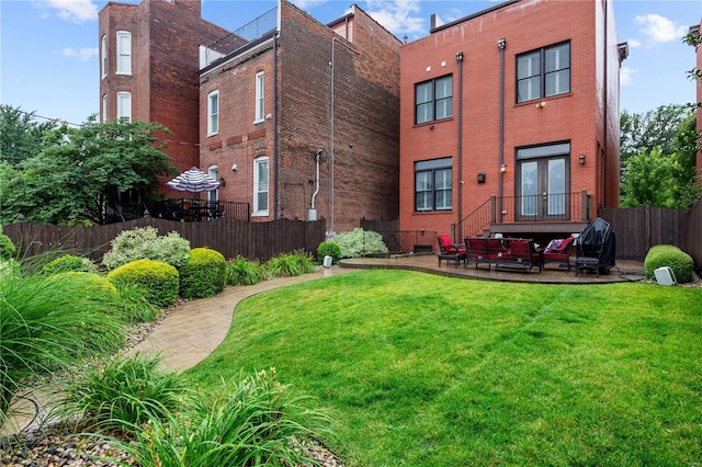 rear view of house with a patio and a lawn