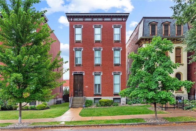 view of front of property featuring a front lawn and cooling unit