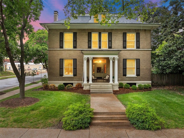 view of front of property featuring covered porch and a lawn