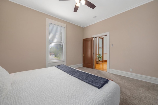 carpeted bedroom featuring ceiling fan and crown molding