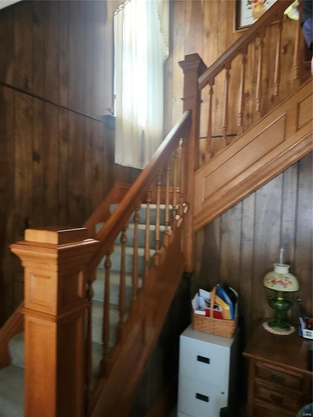 stairway featuring wood walls