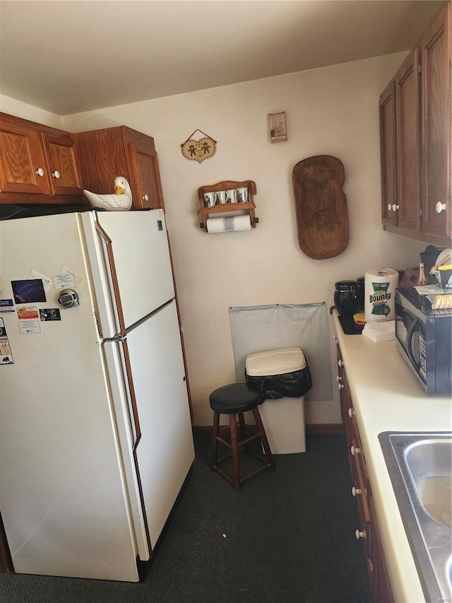 kitchen featuring white refrigerator and sink