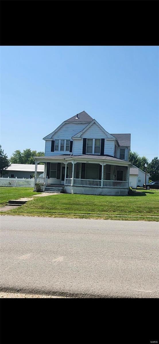 country-style home with a porch and a front lawn