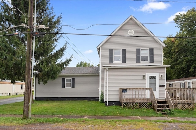 rear view of property featuring a wooden deck and a yard