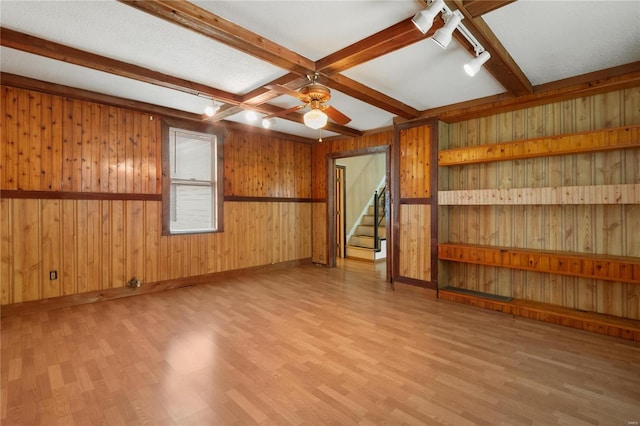 empty room featuring wooden walls and ceiling fan