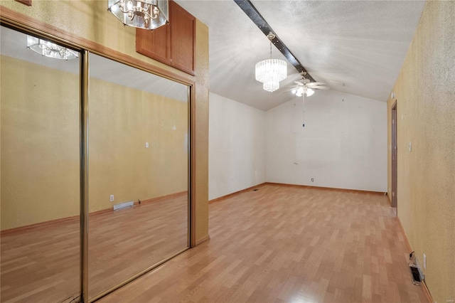 bonus room featuring ceiling fan with notable chandelier, lofted ceiling, and light hardwood / wood-style flooring