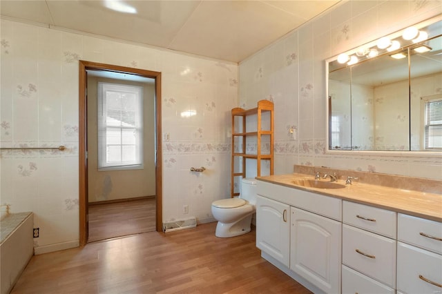 bathroom with wood-type flooring, vanity, tile walls, and toilet