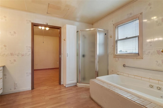 bathroom with tile walls, shower with separate bathtub, vanity, and hardwood / wood-style floors