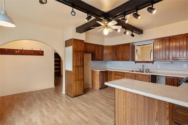 kitchen featuring light wood-type flooring, sink, ceiling fan, and decorative light fixtures