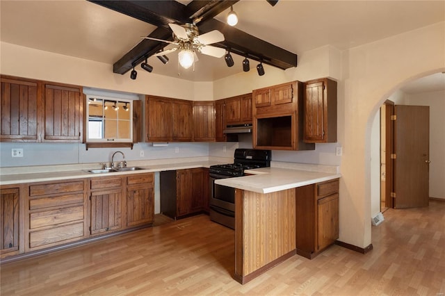 kitchen featuring light hardwood / wood-style flooring, beam ceiling, ceiling fan, and black gas range