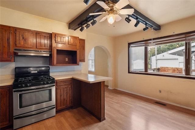 kitchen with ceiling fan, stainless steel gas range oven, light hardwood / wood-style flooring, and kitchen peninsula