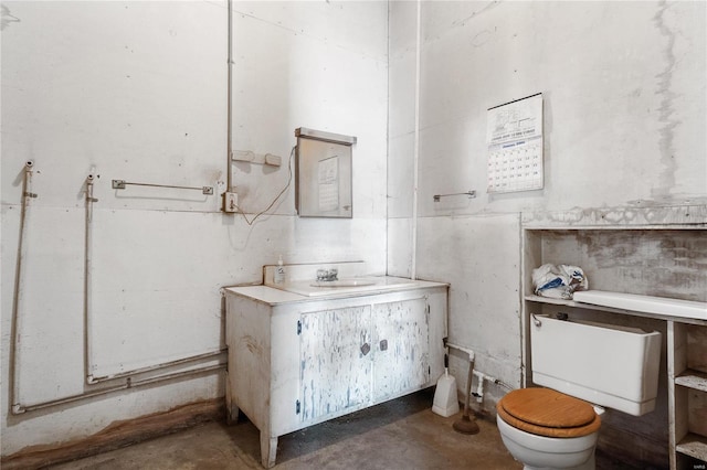 bathroom with concrete flooring, vanity, and toilet