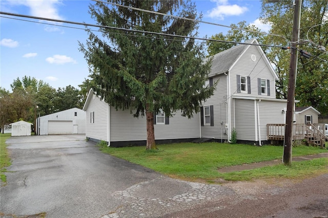 view of front of home with an outbuilding, a garage, and a front yard