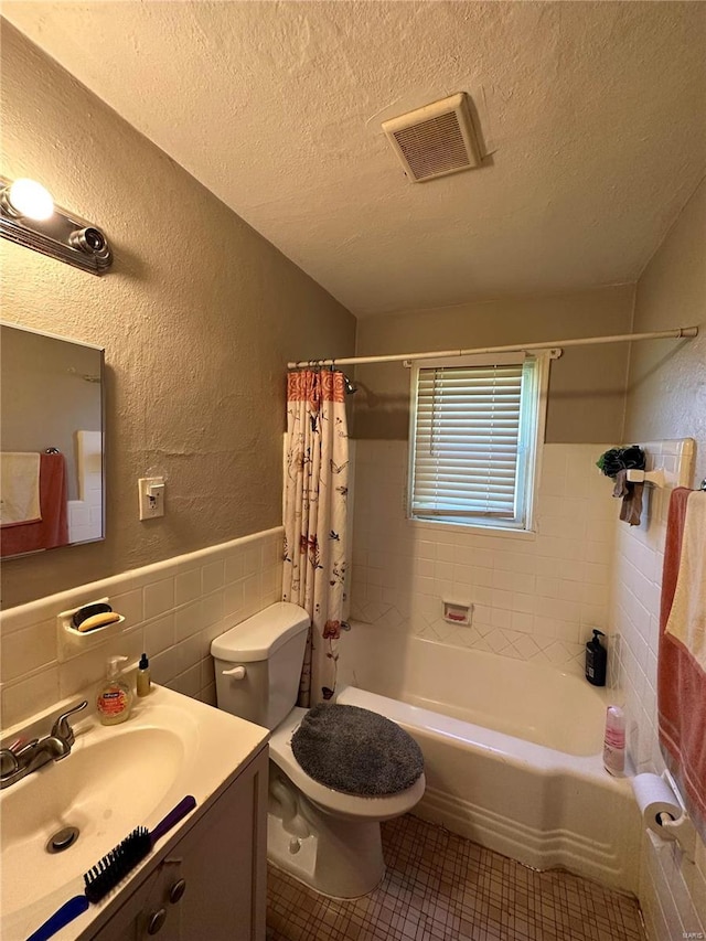 full bathroom with backsplash, toilet, shower / bath combo with shower curtain, vanity, and a textured ceiling