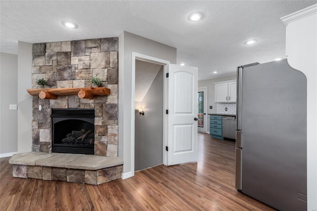 living room featuring hardwood / wood-style flooring and a stone fireplace