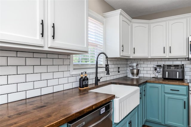 kitchen with backsplash, blue cabinetry, and white cabinets