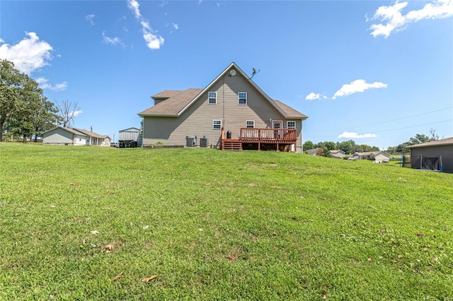 back of property featuring a wooden deck and a lawn